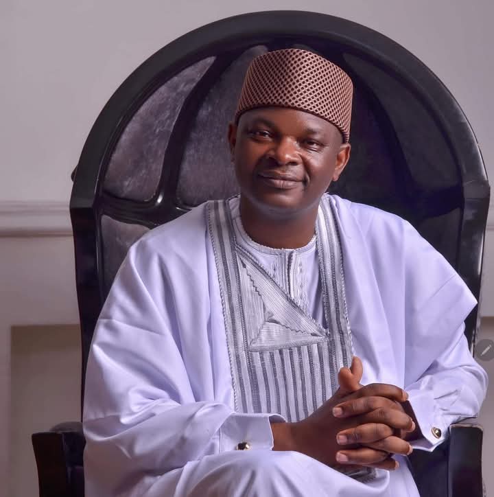 Portrait of Dr. Kehinde Adedapo Makinde in professional attire with agricultural background showing green fields and livestock